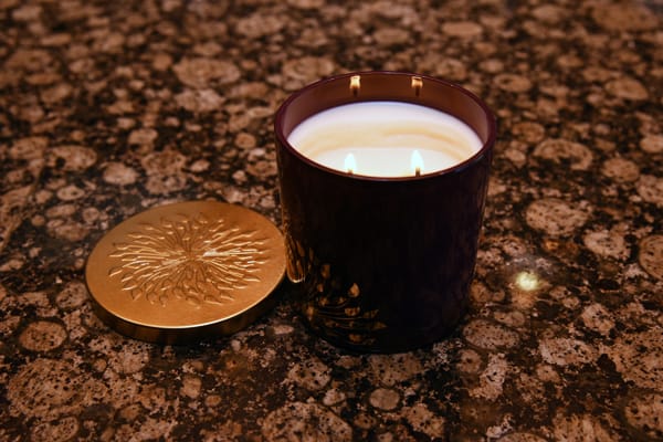 closeup of a candle sitting on a counter next to lid