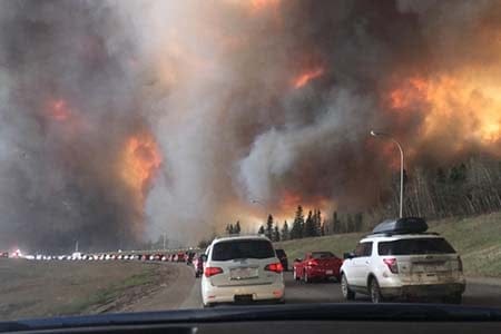 a long line of cars evacuating from a wildfire
