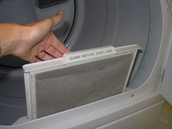 hand pulling out a dryer lint filter