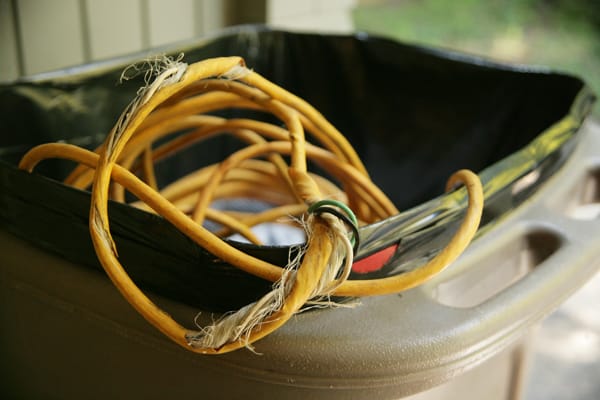 frayed electrical cord disposed of in trash can