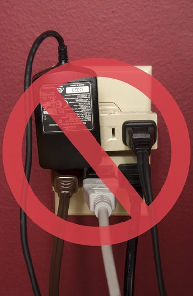 overloaded electrical outlet with a red circle and line overlaid