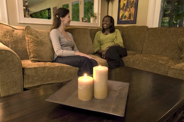 candles on a table, people sitting on a couch