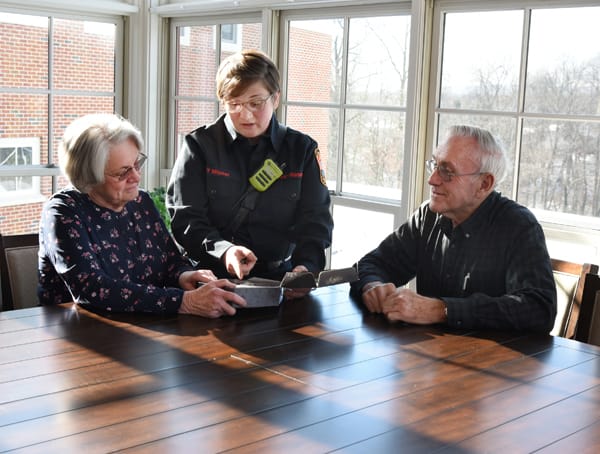 firefighter showing older adults a smoke alarm kit