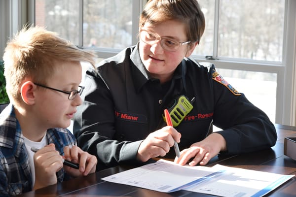 firefighter helping a boy make a fire escape plan