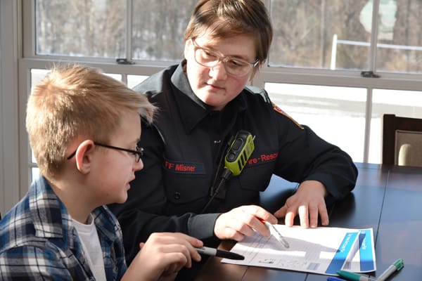 firefighter showing a boy how to make a home fire escape plan