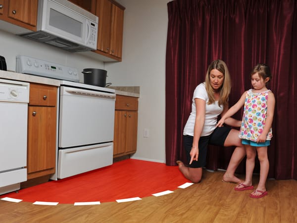 mother pointing to 3-foot safety zone around stove to child