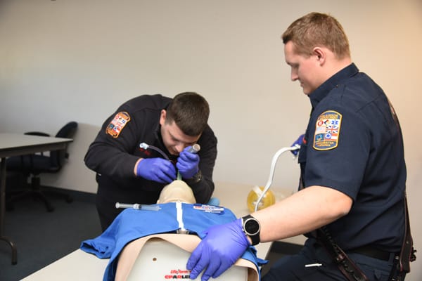 EMTs intubating training mannequin
