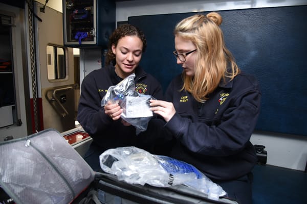 EMTs checking medical supplies in ambulance