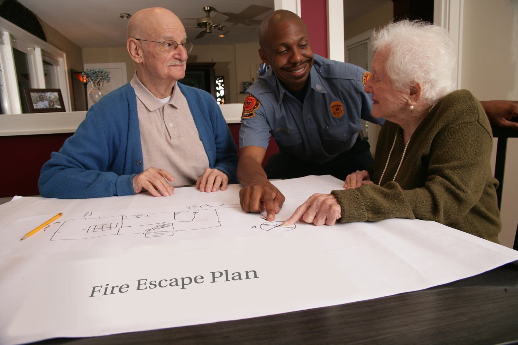 firefighter helping older adults make an escape plan