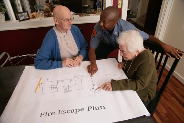 firefighter helping older adults make a fire escape plan