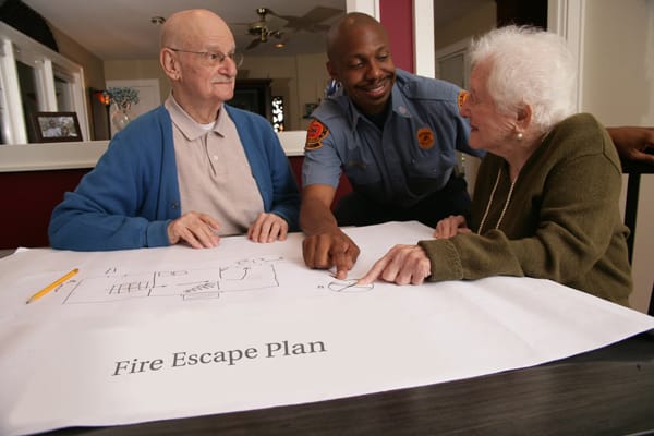 firefighter helping older adults make a fire escape plan