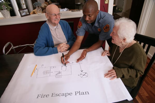 firefighter helping older adults make a fire escape plan