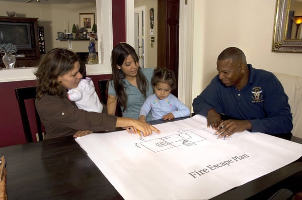firefighter helping a family make a fire escape plan