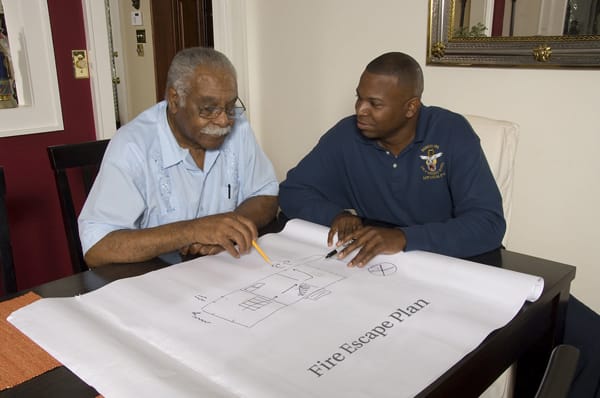 firefighter helping an older adult make a fire escape plan