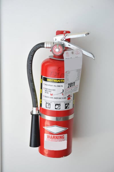 red fire extinguisher hanging on a wall