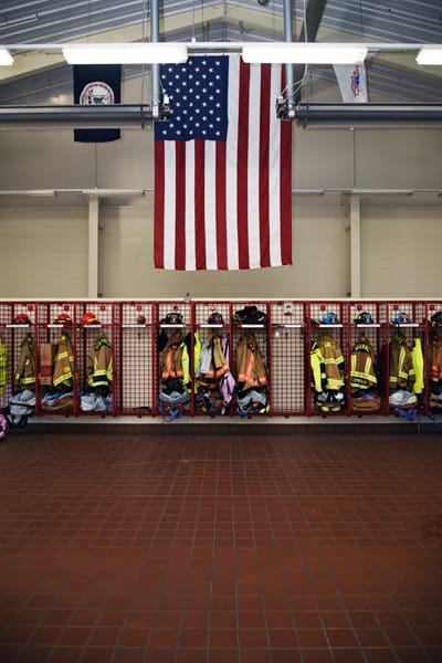 American flag hanging over bunker gear storage in fire station