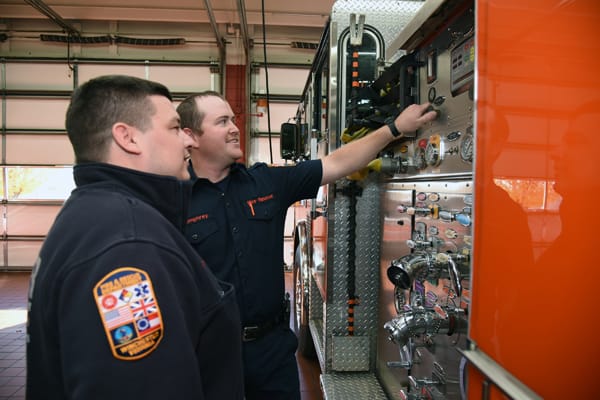 firefighters looking at engine instrument panel