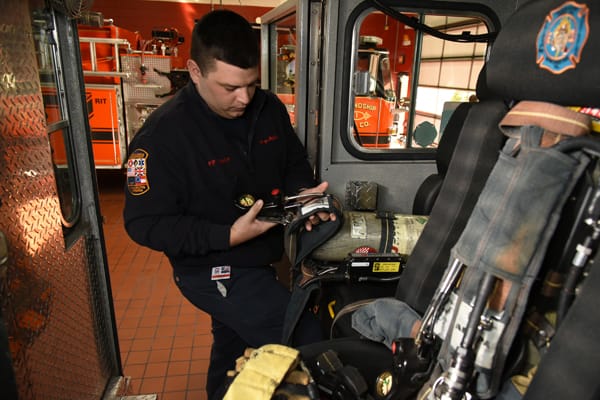 firefighter looking at equipment inside cab