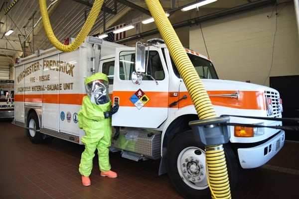 firefighter in hazmat suit getting into a hazmat unit