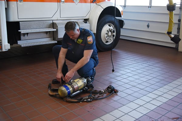 firefighter inspecting SCBA