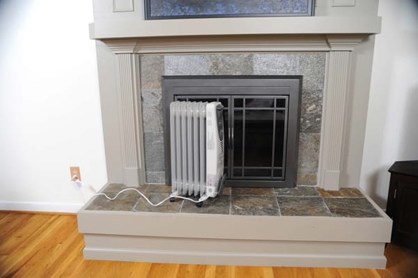 portable heater sitting in front of a fireplace