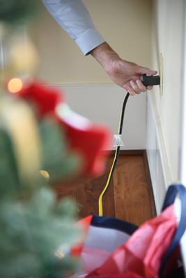 man unplugging Christmas tree lights