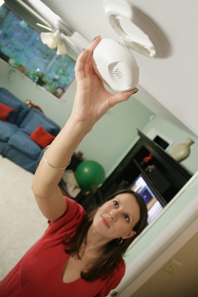woman installing a smoke alarm