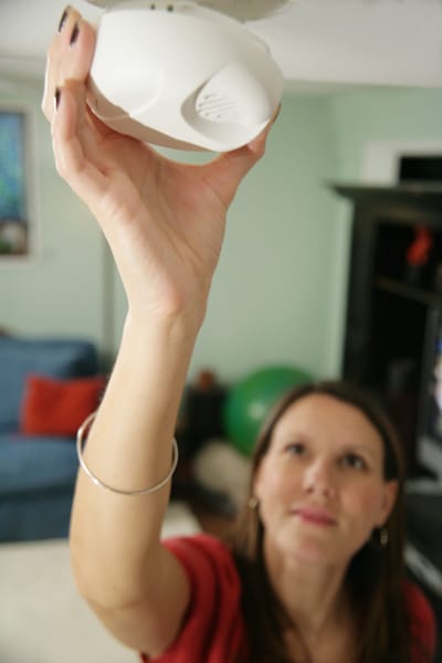 woman installing a smoke alarm
