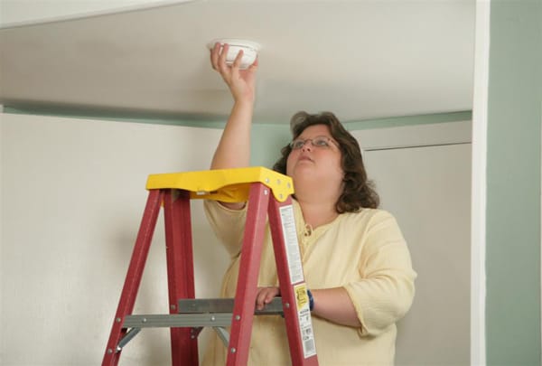 woman installing a smoke alarm