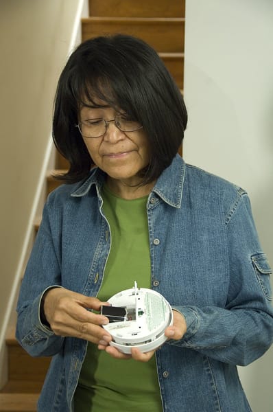 woman changing a smoke alarm battery