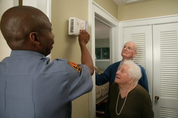 firefighter testing a smoke alarm for older adults