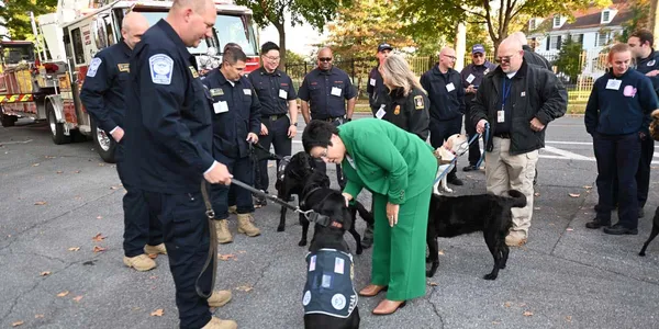 U.S. Fire Administrator Dr. Lori Moore-Merrell is photographed with fire investigation personnel and their accelerant detection canines.