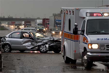 ambulance at the scene of a car accident on a busy highway