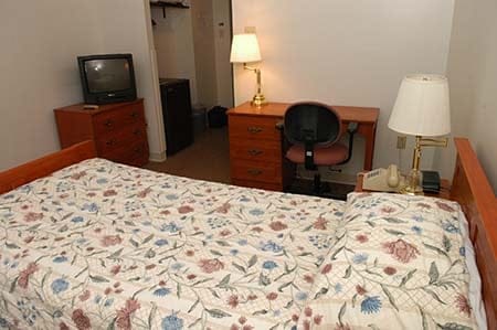 dorm room showing bed, tv and desk