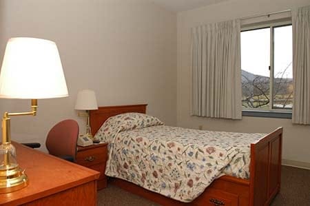 dorm room showing lamp, bed and window