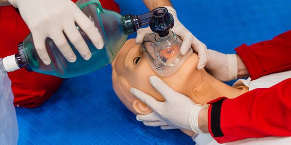 Photo of EMS workers in training establishing an airway on a mannequin.