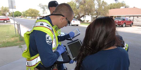 Photo of the fire service using a laptop to enter data.