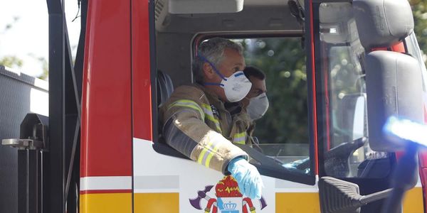 firefighters riding in apparatus cab wearing N95 masks