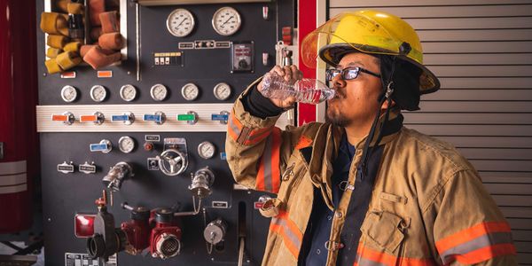 Photo of a firefighter drinking water on a hot day