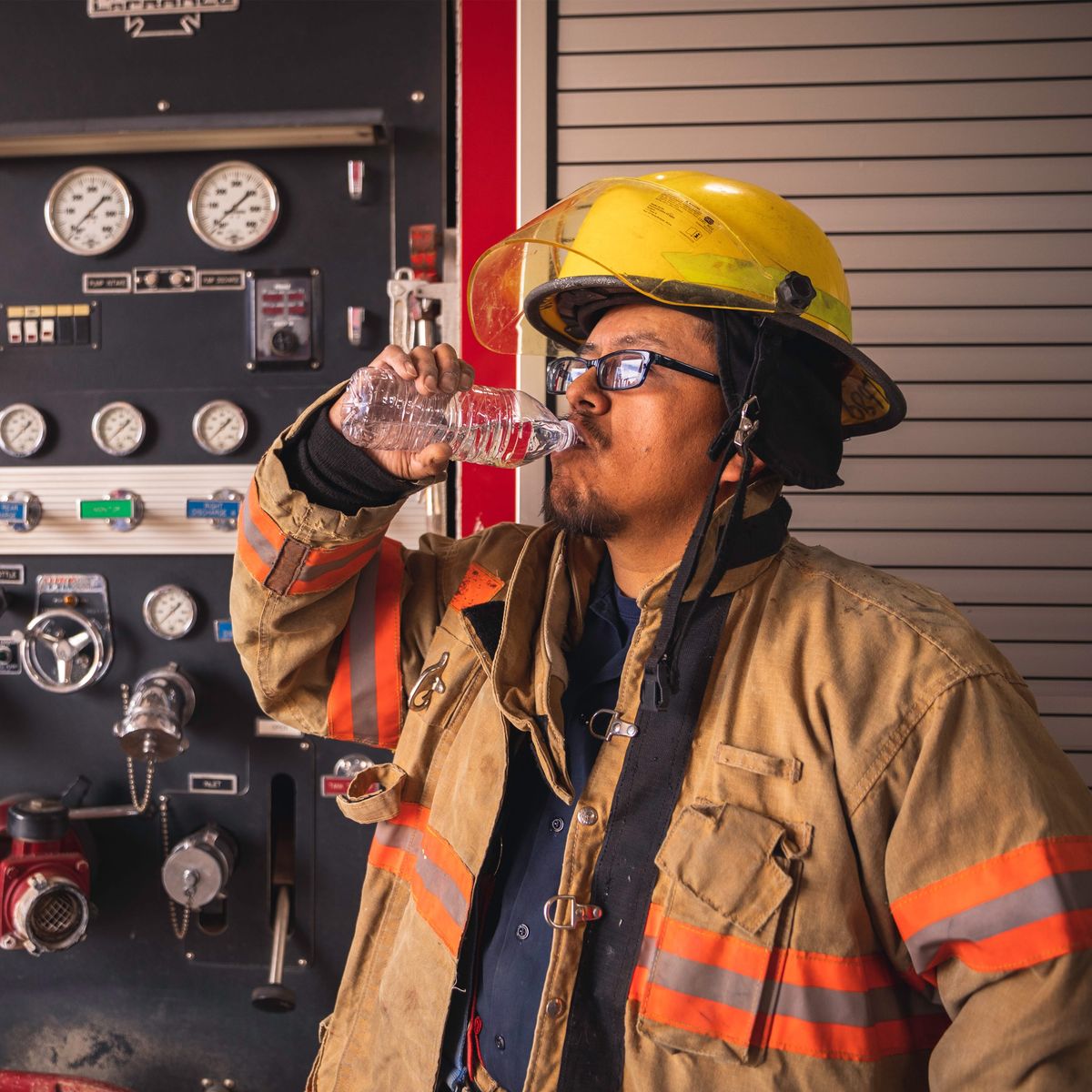 Photo of a firefighter drinking water on a hot day