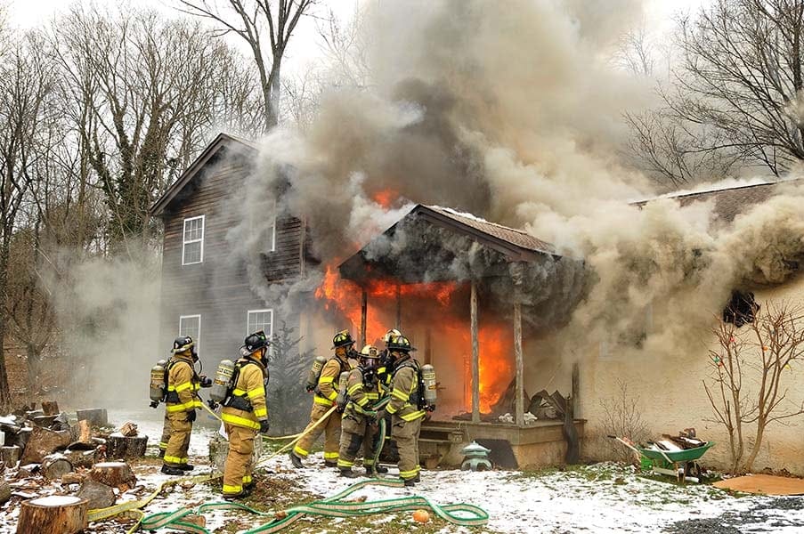 5 firefighters fighting a house fire