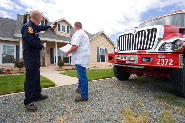 firefighter pointing out a home safety issue to a resident