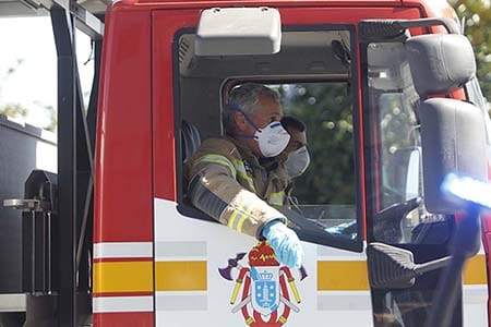 firefighters wearing masks in engine cab