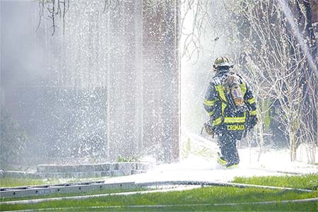 firefighter with firefighting foam surrounding him