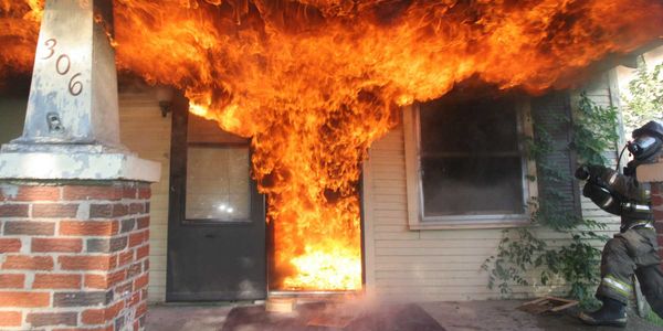 photo of a firefighter fighting a residential fire