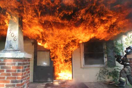 photo of a firefighter fighting a residential fire