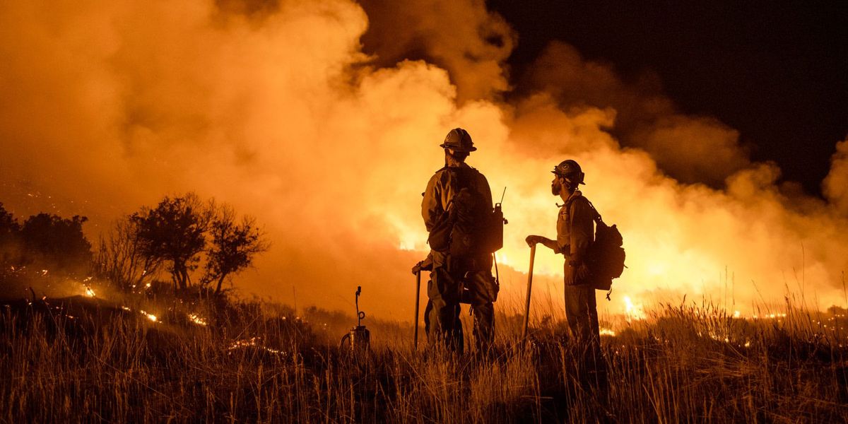 Photo of firefighters fighting off a large wildfire