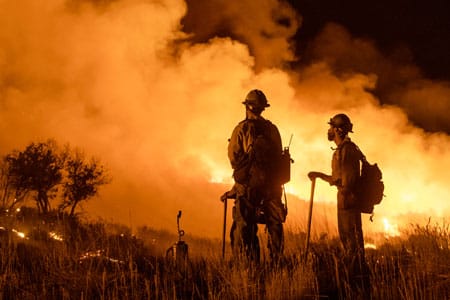 firefighters fighting off a large wildfire