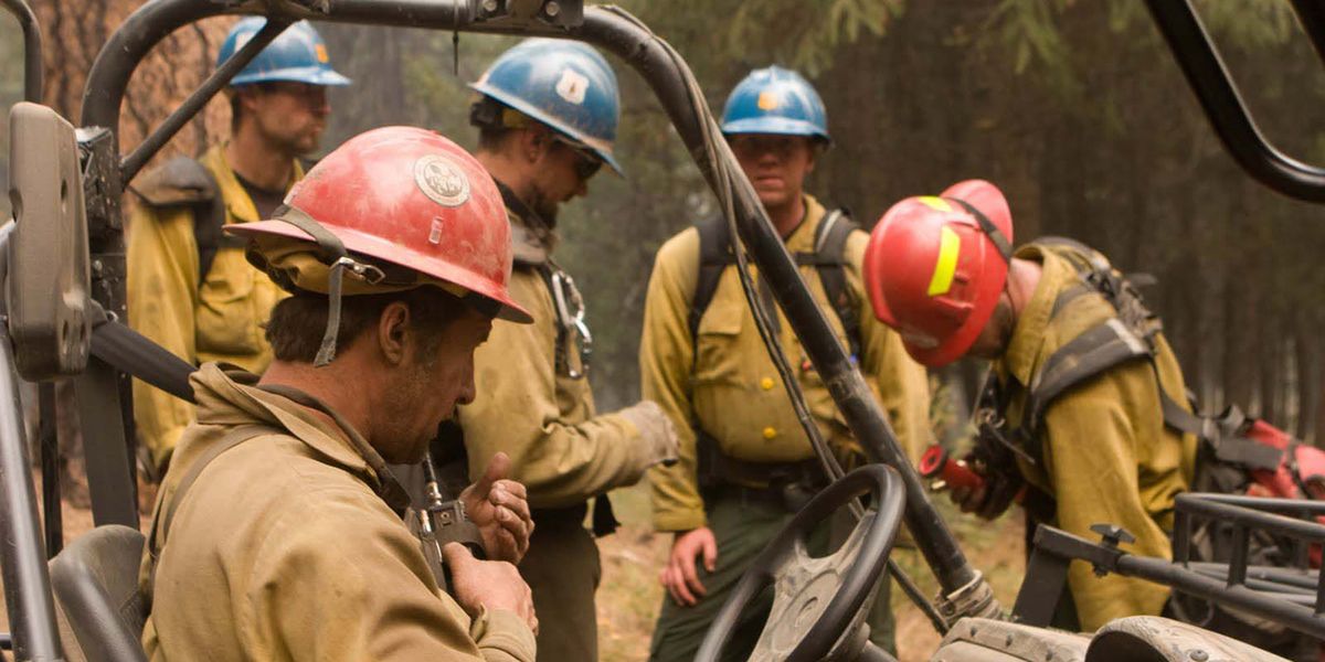 Photo of firefighters huddled together on duty